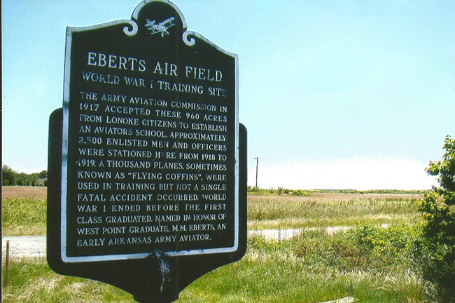 "Eberts Air Field" sign in a field by a gravel road