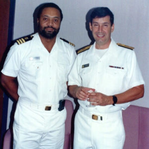 African-American man with beard and white man in matching uniforms standing together