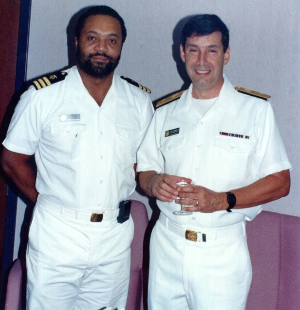 African-American man with beard and white man in matching uniforms standing together