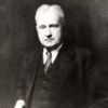 White man standing in suit and tie
