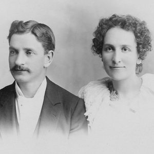 Portrait of white man in suit and white woman with curly hair in dress