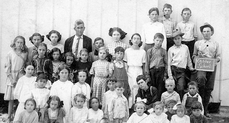 Group of white children with white man in suit and tie