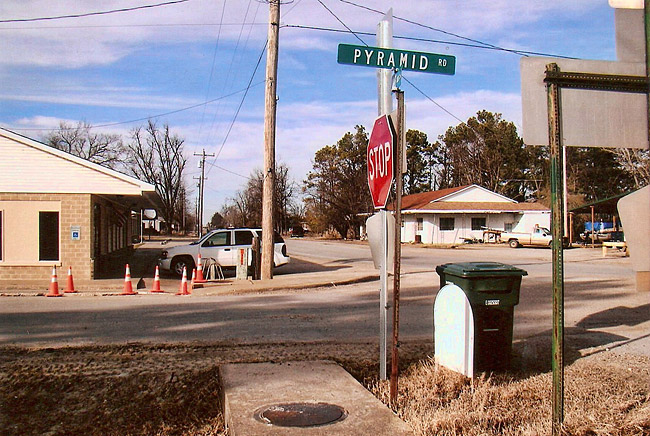 Street intersection with signs and single-story buildings