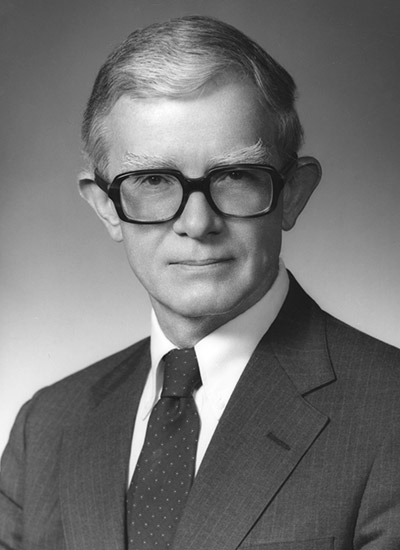 White man with large glasses in suit and tie