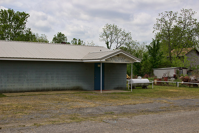 Concrete block building with covered entrance propane tank and metal shed