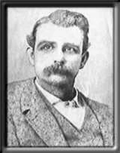 Framed portrait of white man with mustache in suit