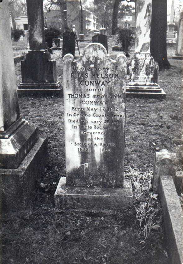White marble grave marker with stains of age surrounded by other grave markers