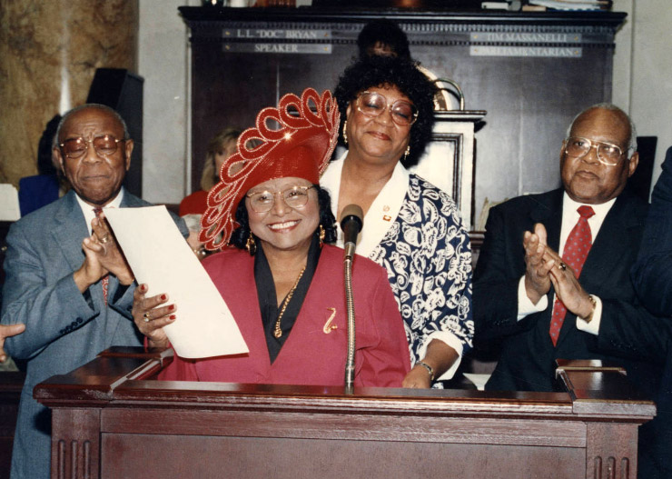 African-American men and women at lectern