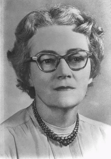 White woman with glasses and bead necklace