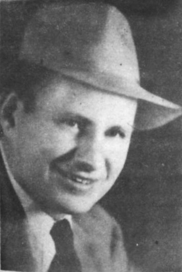 White man smiling in hat and suit