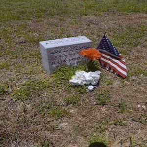 "My darling Julia Pridgin" gravestone with flowers and small American flag in cemetery