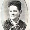 White woman in dress with earrings in oval frame