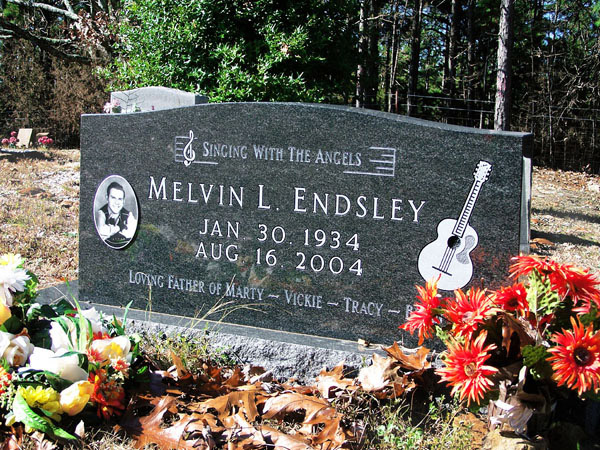 "Melvin L Endsley" gravestone with guitar engraving and portrait on it in cemetery