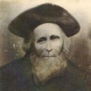 Older white man with beard in hat and coat