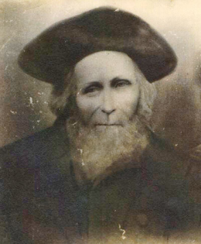 Older white man with beard in hat and coat