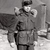 White man in military coat with fur shoulder pads and tent