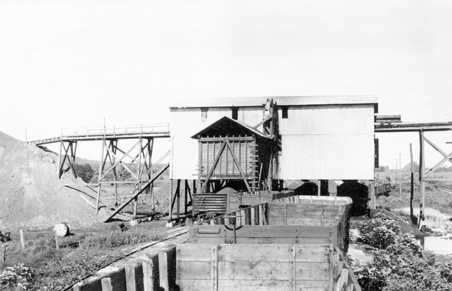 Two-story mining building with carts and machinery