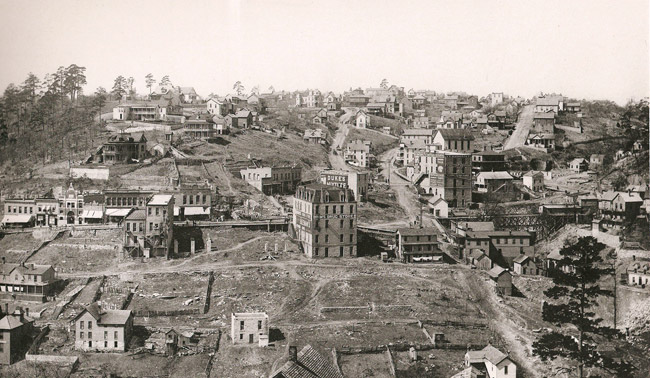 View of town with multistory buildings on dirt roads