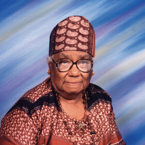 Older African-American woman with glasses hat and dress