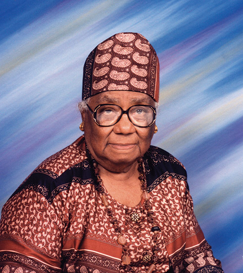 Older African-American woman with glasses hat and dress