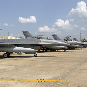 Row of jet fighters parked on base with stylized Razorback figure on the tails