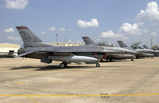 Row of jet fighters parked on base with stylized Razorback figure on the tails
