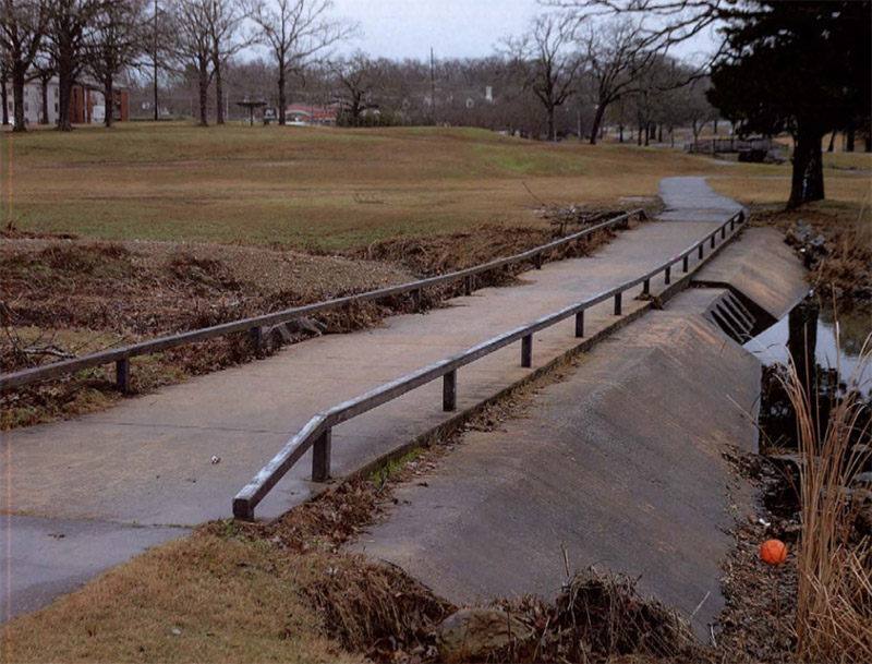 Concrete spillway bridge with low railing on golf course