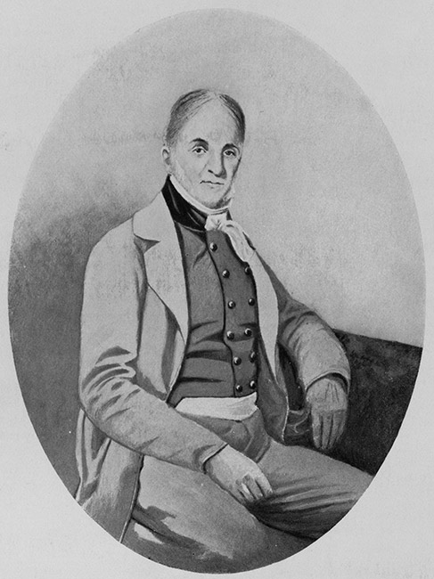 White man in suit and vest with round buttons sitting down