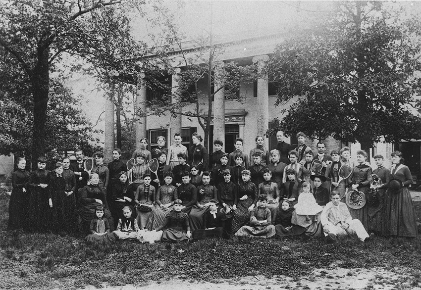 Large group of people in front of building fronted by columns