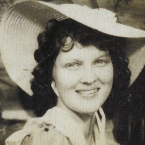 Young white woman smiling under large hat