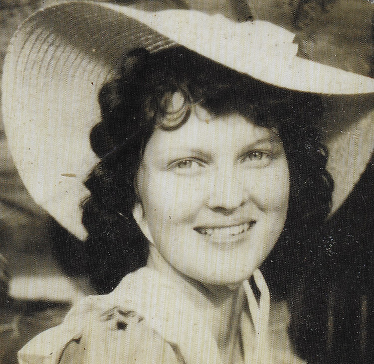Young white woman smiling under large hat