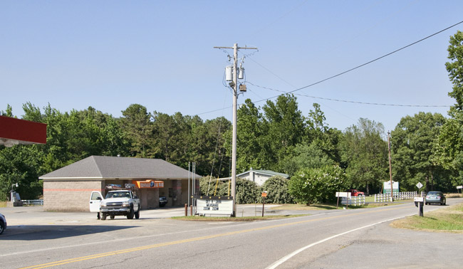 Side of gas station and building on paved road