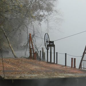 Empty ferry on foggy river bank