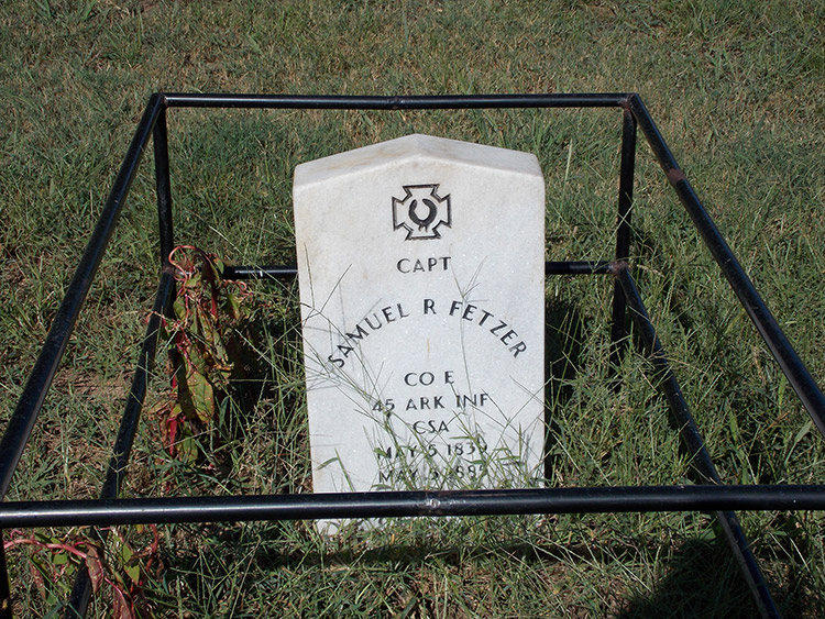 White marble gravestone with protective metal fence