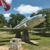 "U.S. Air Force" plane displayed on pedestals with flag pole in park