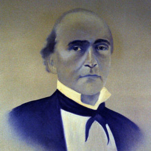 Bald white man in black suit and white shirt and bow tie