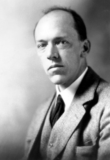 Middle-aged white man posing in suit and tie