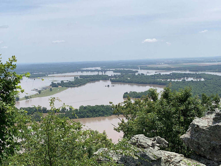 Flooded river valley seen from elevated rocky outcropping
