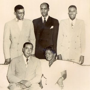 African-American woman with husband and three sons, all dressed up and posing for group photo