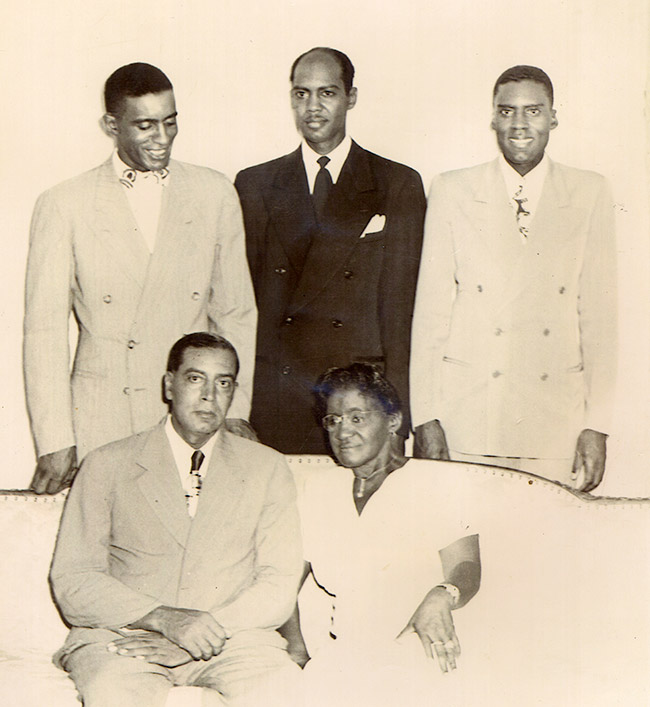 African-American woman with husband and three sons, all dressed up and posing for group photo