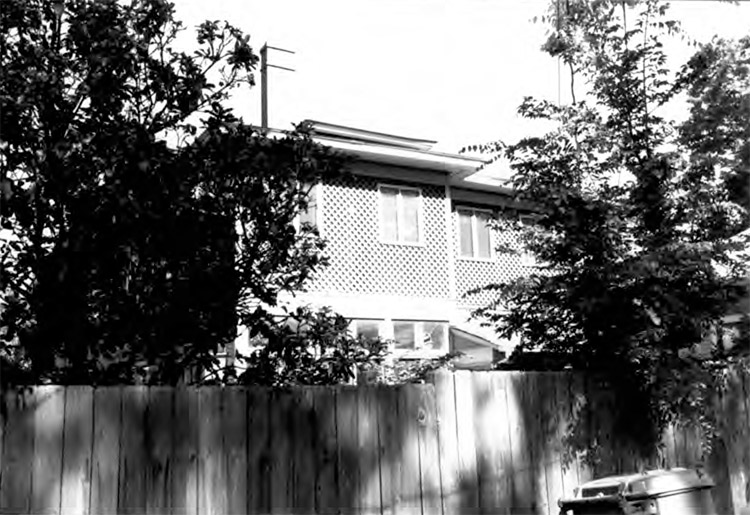 Side view of multistory house with privacy fence