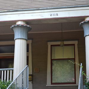 Close-up of covered porch with columns and framed windows