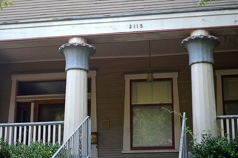 Close-up of covered porch with columns and framed windows