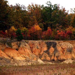 Ridge with fall foliage and exposed multicolored soil