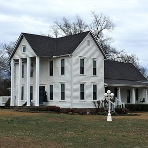 Two-story house with four columns in front and covered side porch