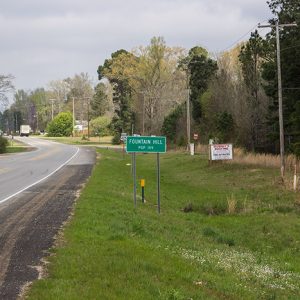 "Fountain Hill" road sign on two-lane highway