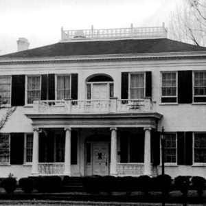 Two-story house with covered porch and balcony with arched doors