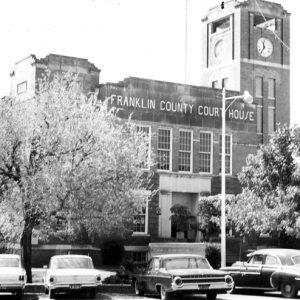 Brick building labeled "Franklin County Court House" with clock tower and parking lot