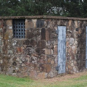 Small stone building with two metal doors and barred window