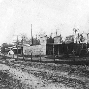 Lumber storage buildings with railroad tracks in the foreground